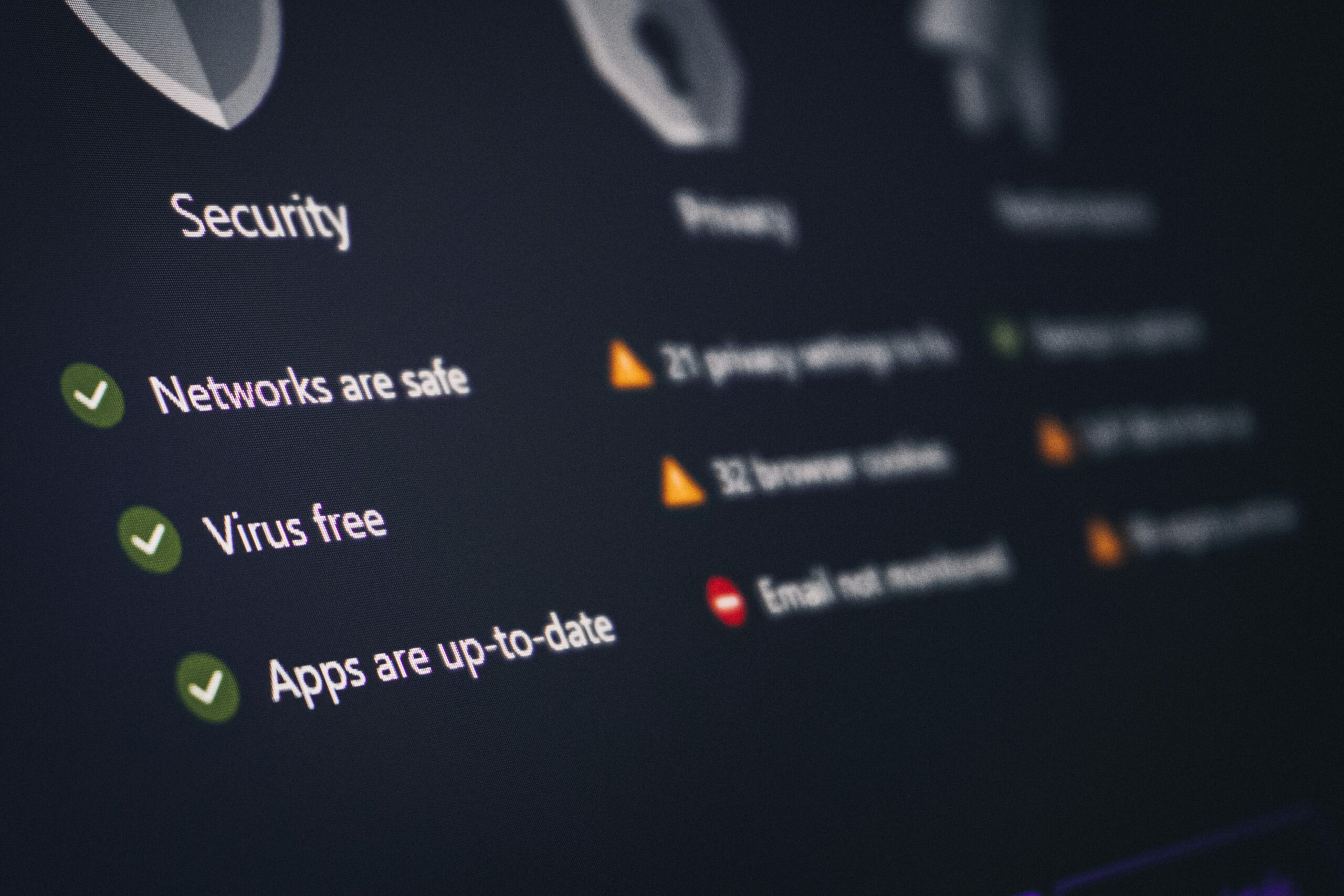 A developer monitors an AI agent dashboard showing security alerts on multiple screens in a dark server room